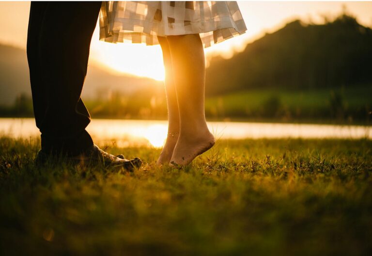 man and woman standing on green grass