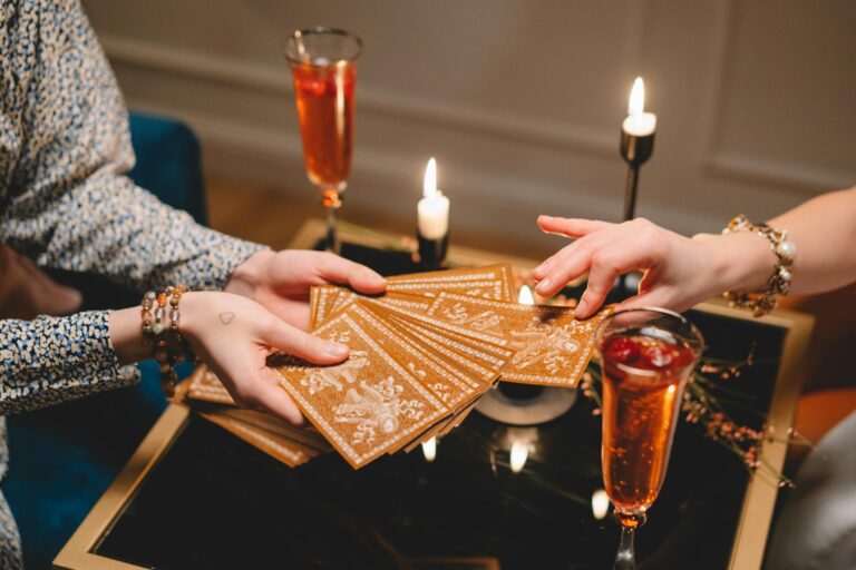 close up of woman picking a tarot card from a deck held by another woman